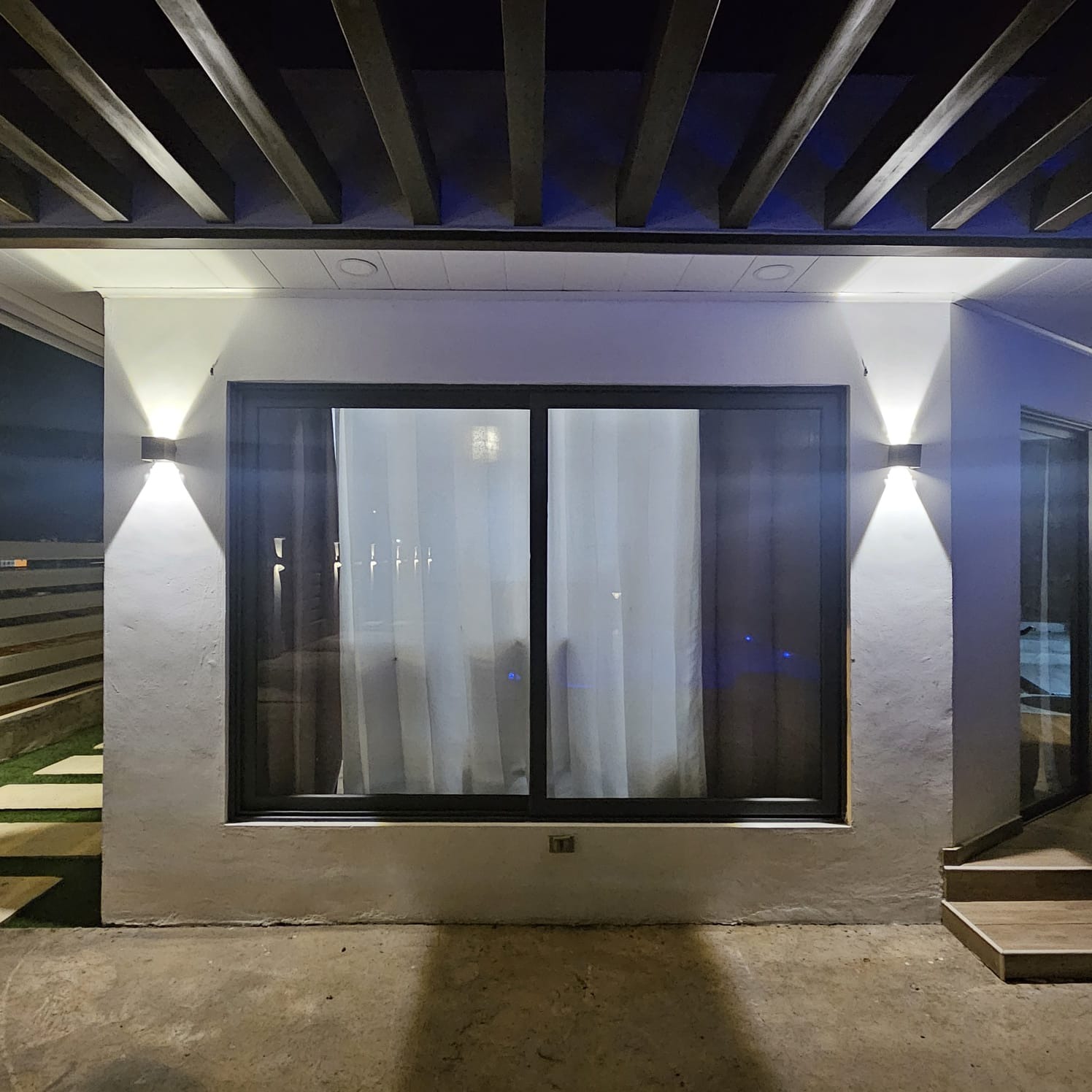 Fachada nocturna con apliques exteriores